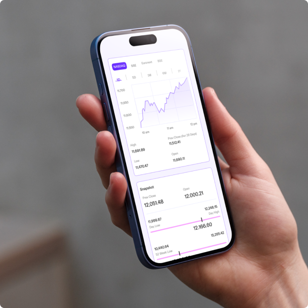 Hand holding a smartphone displaying a stock market chart and price data.
