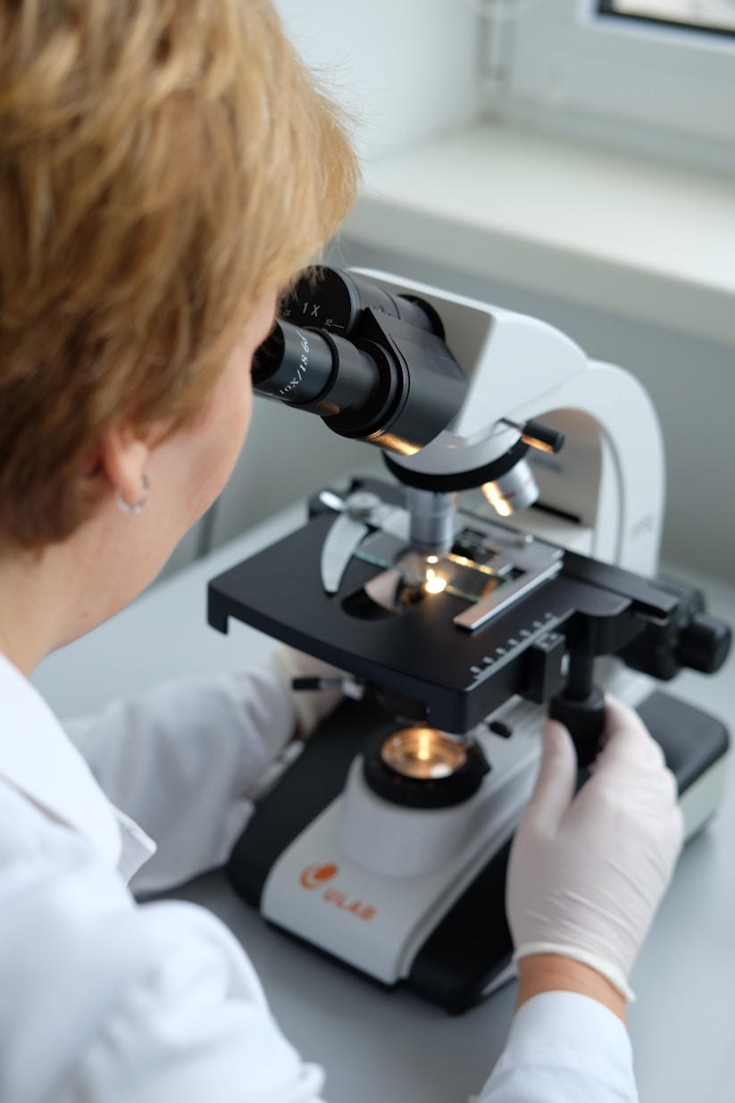 woman looking into microscope
